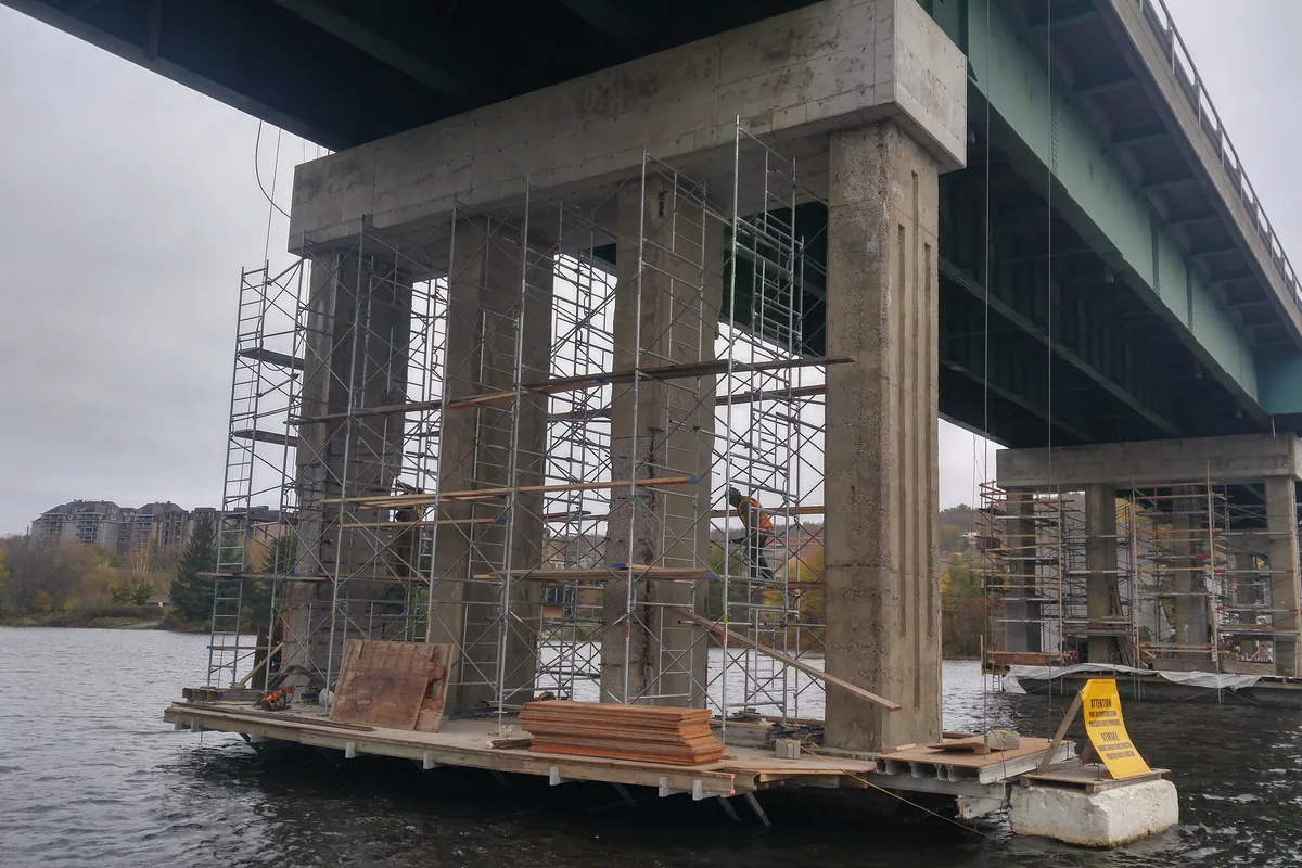 Barge-mounted scaffolding beneath a bridge