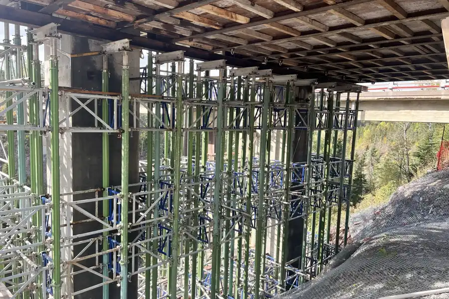 Shoring towers under an overpass deck, in a ravine — St-Clément