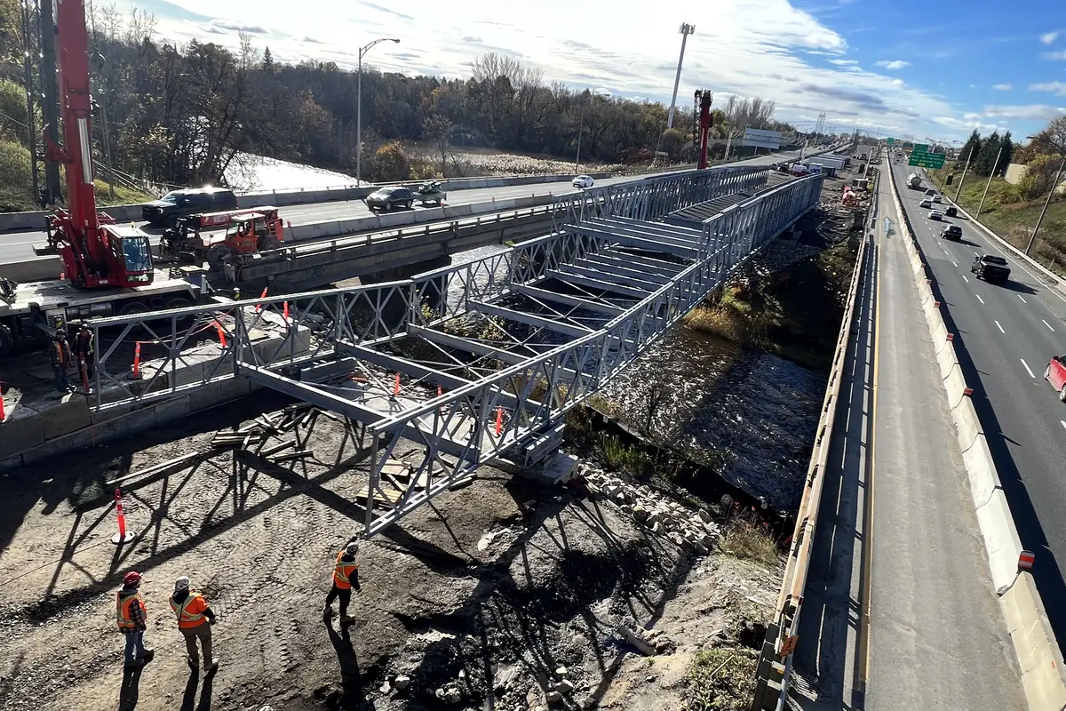 Avancement du tablier de pont temporaire pendant la poussée, équipe en chantier
